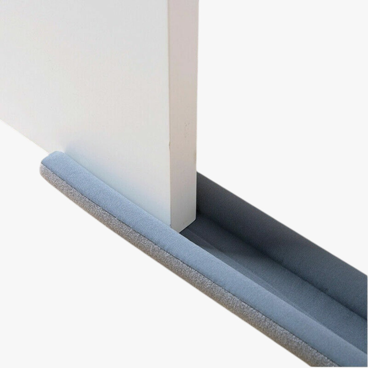 Roselva grey double-sided foam door bottom weather stripping seal installed on a white door to block drafts and noise.