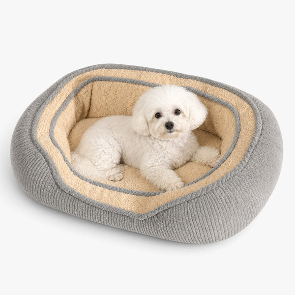 Roselva all-weather dog bed with a white Bichon Frise resting inside on a soft beige and grey cushioned base.